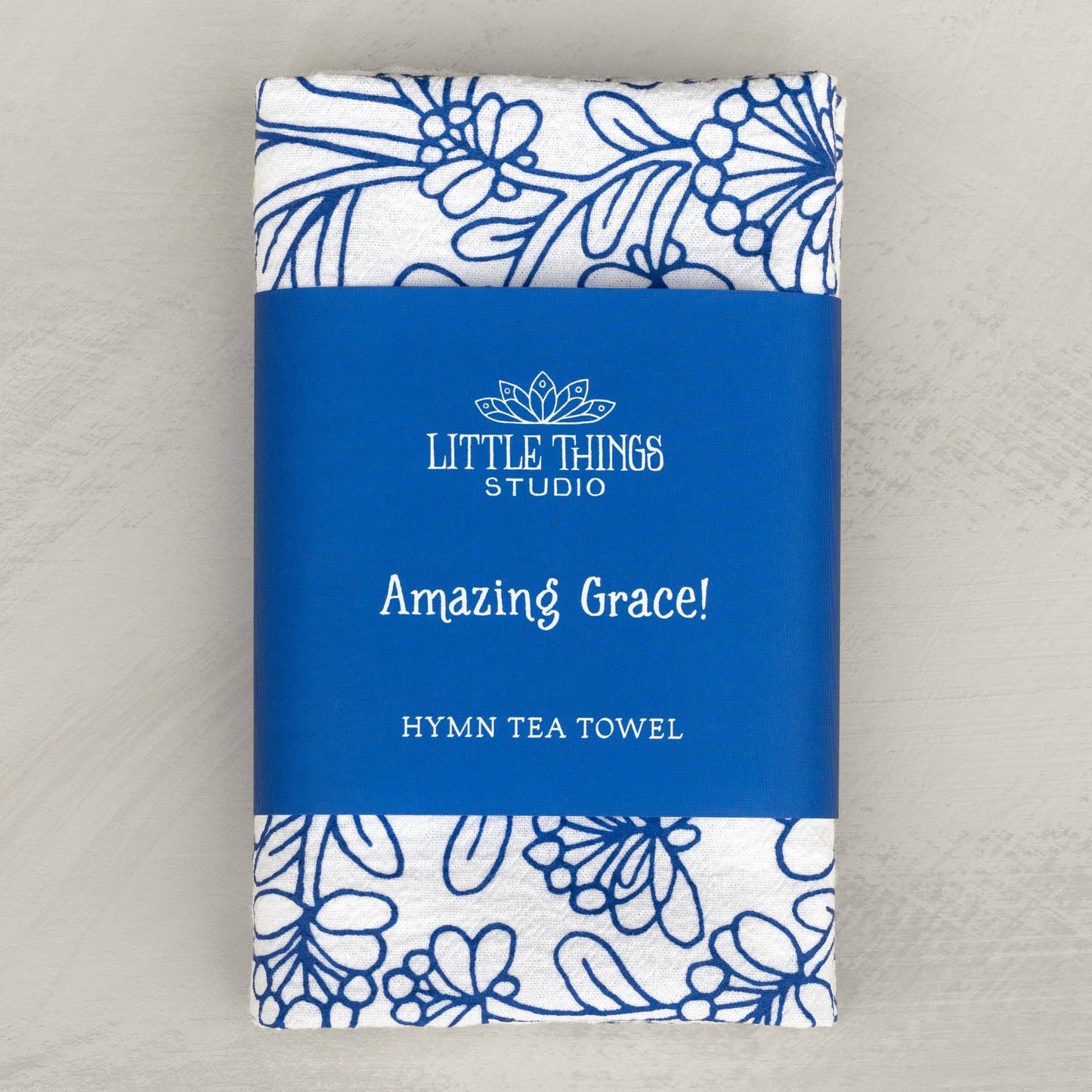 Folded hymn tea towel with belly band packaging and illustrated design