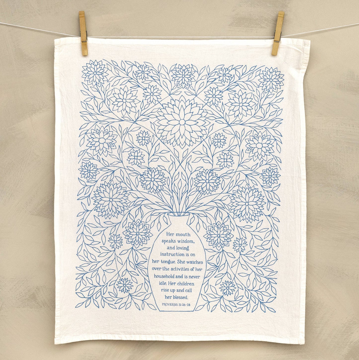 Close-up of delicate hand-lettered verse from Proverbs 31 on soft white cotton fabric