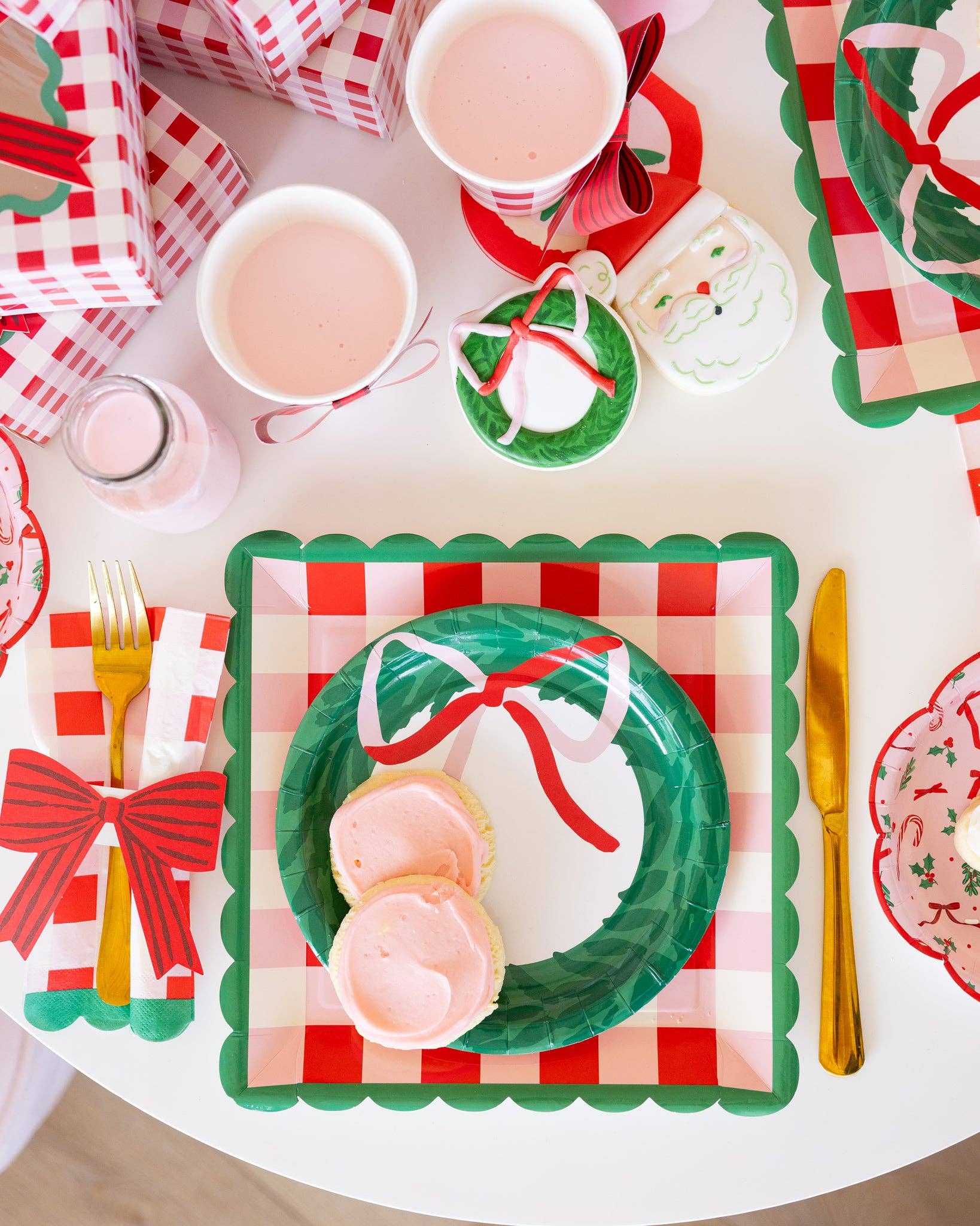 Christmas-themed table setting with green plates, red checkered placemats, and festive decorations.
