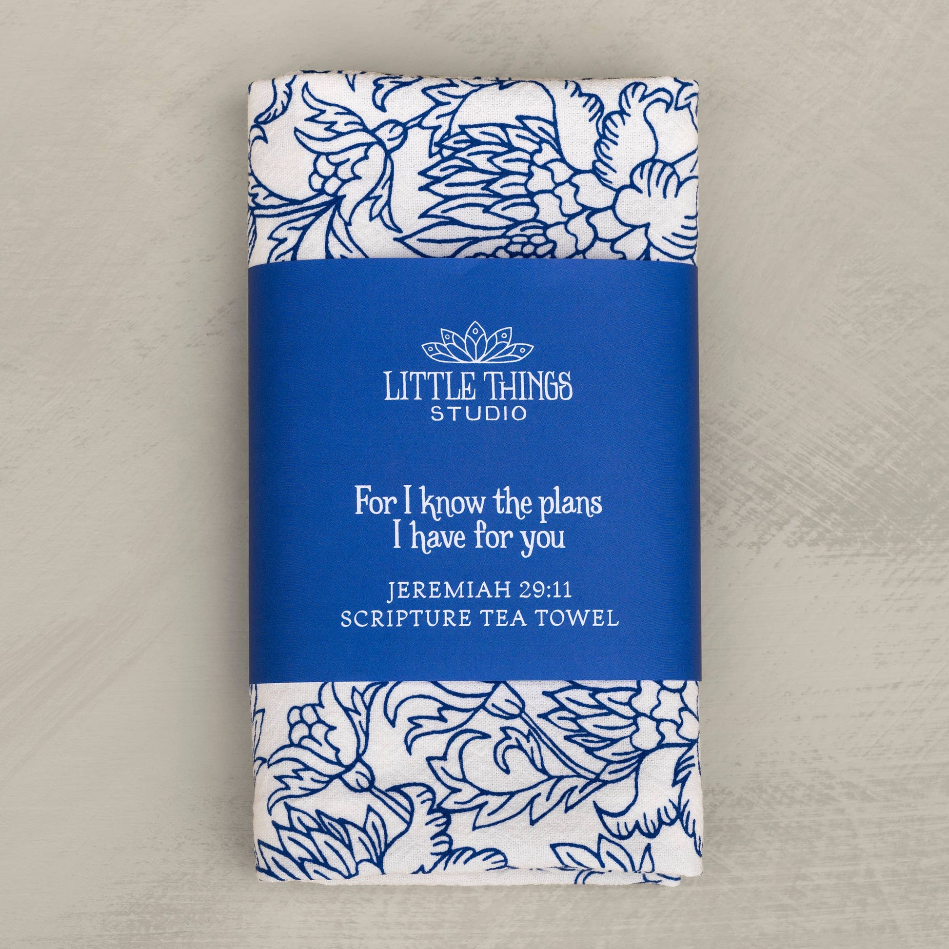 Flat lay of Jeremiah 29:11 scripture tea towel in diode blue on a wooden kitchen surface