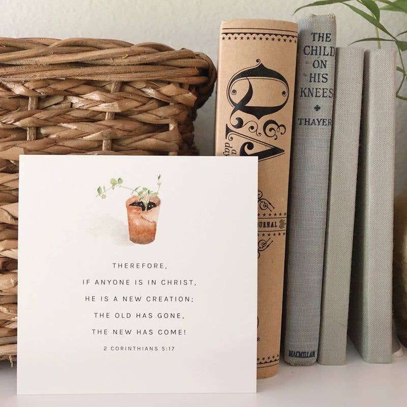 Card with inspirational quote on a surface with books and a basket.