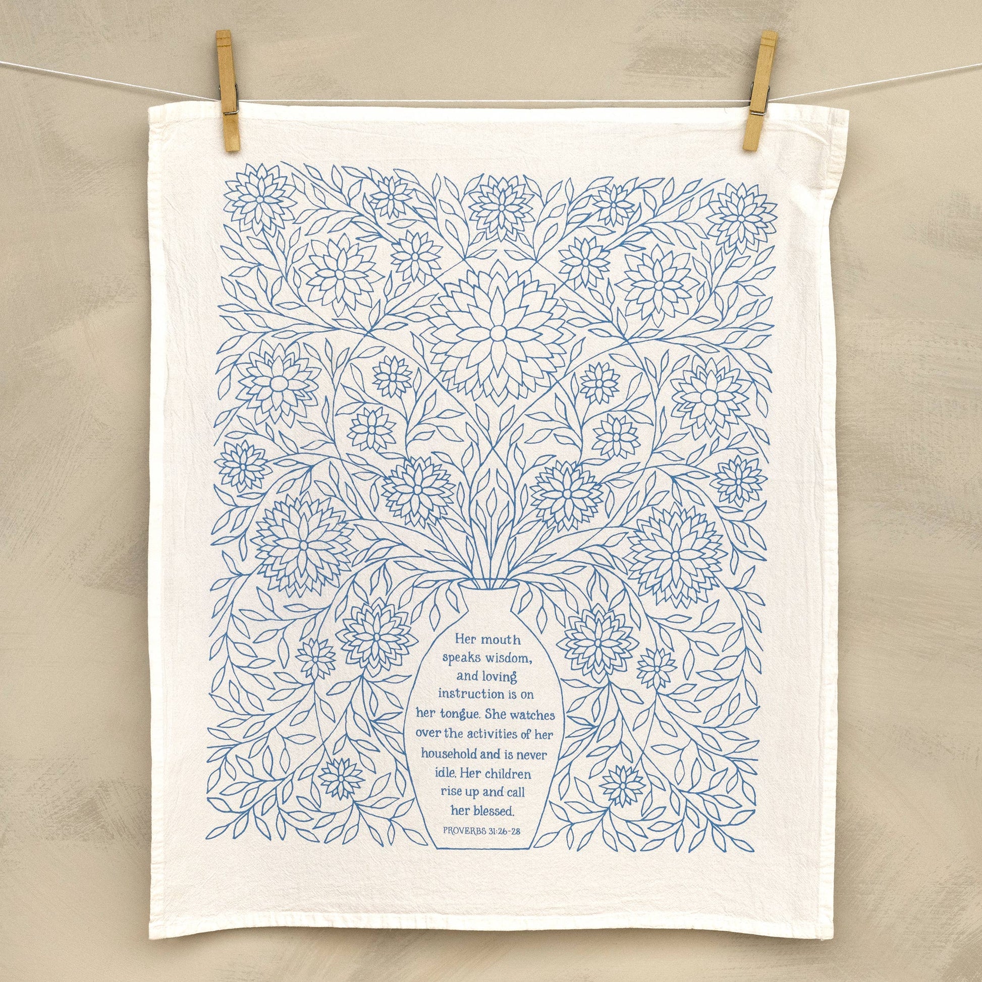 Close-up of delicate hand-lettered verse from Proverbs 31 on soft white cotton fabric
