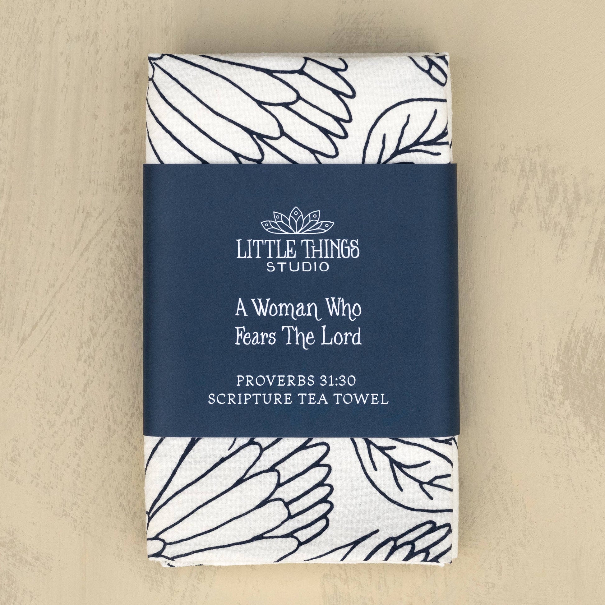 Folded tea towel with belly band packaging featuring Proverbs 31 text