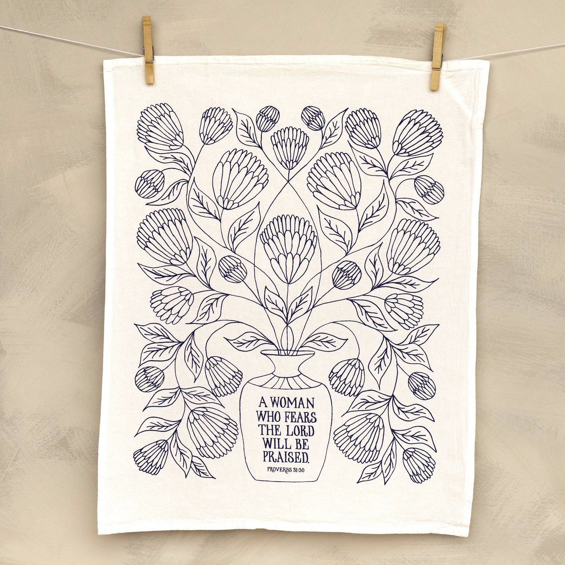 Close-up of hand-lettered Bible verse printed on white cotton fabric