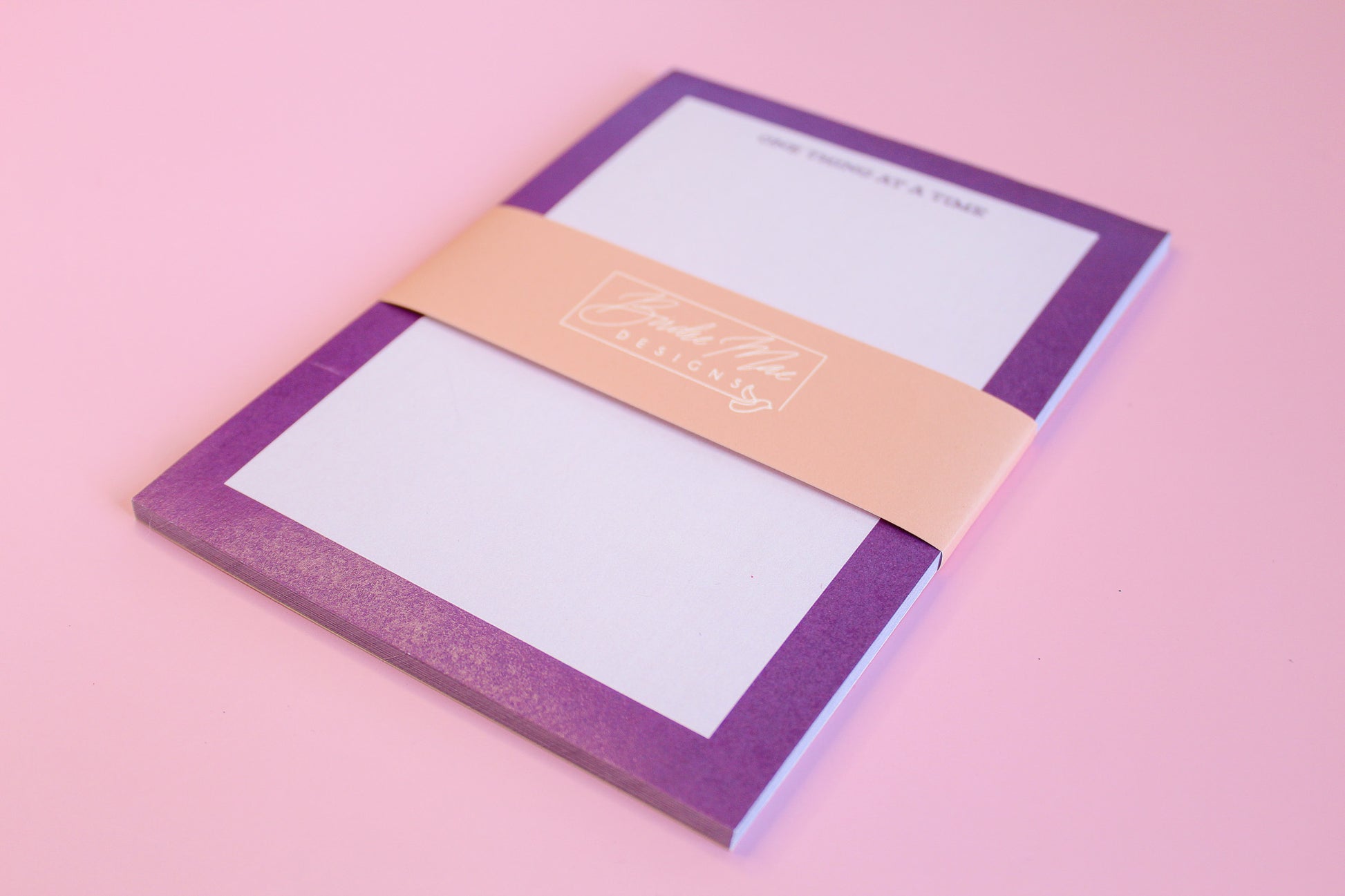 One Thing At A Time' notepads, purple notepad